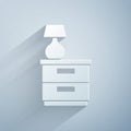 Paper cut Furniture nightstand with lamp icon isolated on grey background. Paper art style. Vector