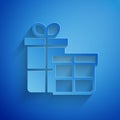 Paper cut Gift box icon isolated on blue background. Merry Christmas and Happy New Year. Paper art style. Vector Royalty Free Stock Photo