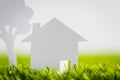Paper cut of house and tree on green grass Royalty Free Stock Photo