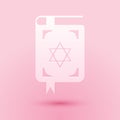 Paper cut Jewish torah book icon isolated on pink background. Book of the Pentateuch of Moses. On the cover of the Bible is the