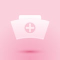 Paper cut Nurse hat with cross icon isolated on pink background. Medical nurse cap sign. Paper art style. Vector Royalty Free Stock Photo
