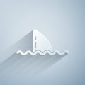 Paper cut Shark fin in ocean wave icon isolated on grey background. Paper art style. Vector Royalty Free Stock Photo