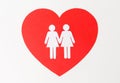 Paper cutout of female gay couple on red heart