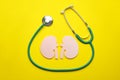 Paper cutout of kidneys and stethoscope on yellow background, flat lay Royalty Free Stock Photo