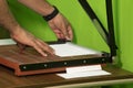 Paper cutter cutting paper on wooden desk. human hand holding paper cutter Royalty Free Stock Photo