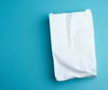 Paper disposable food bag on a blue background, concept of delivery and ordering food