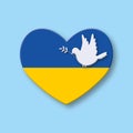 Paper dove or pigeon of peace with Ukrainian flag heart shape on soft blue background. Concept for Peace and stop the war. Royalty Free Stock Photo