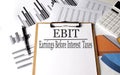 Paper with EBIT on a chart background, business