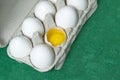 Paper Egg Tray with white eggs. chicken white eggs close up. broken chicken white egg. eggs on green background Royalty Free Stock Photo