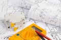 Paper electrical engineering drawings with circuit breaker and multimeter Royalty Free Stock Photo