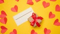 Paper envelope and box tied with a red ribbon and small hearts on a yellow background Royalty Free Stock Photo