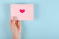 Paper envelope with red heart composition on blue background