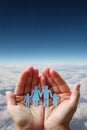 Paper family in hands on aerial sky view background Royalty Free Stock Photo