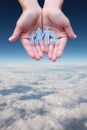 Paper family in hands on aerial sky view background Royalty Free Stock Photo