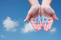 Paper family in hands on blue sky background welfare concept Royalty Free Stock Photo