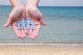 Paper family in hands on sea beach background welfare concept Royalty Free Stock Photo