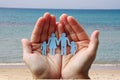 Paper family in hands on sea beach background welfare concept Royalty Free Stock Photo