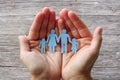 Paper family in hands on wooden background welfare concept Royalty Free Stock Photo