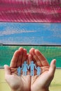 Paper family in hands on wooden coloured background welfare concept Royalty Free Stock Photo