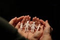 A paper family holding hands, with the protection of the hands of a woman, in turn in the hands of the man, with a view from Royalty Free Stock Photo