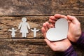 Paper family and a man holding a heart in his hands Royalty Free Stock Photo
