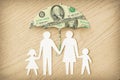 Paper family silhouette with umbrella made of dollar banknotes on wooden background - Concept of family financial protection