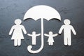 Paper family under an umbrella on a black background concept caring, insurance Royalty Free Stock Photo