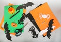 Paper felt Halloween hand made crafts. Felt pumpkin, spider, bat, eyes decorations on gray background. Scissors and materials.