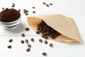 Paper filter, ground coffee and beans on white wooden table Royalty Free Stock Photo