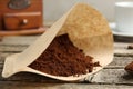Paper filter and ground coffee on wooden table, closeup Royalty Free Stock Photo