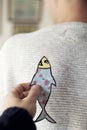 Paper fish in the back of man for april fools day Royalty Free Stock Photo