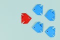 Paper fish swimming swimming against the current in other direction than different colored fish Royalty Free Stock Photo