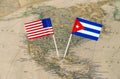 The United States of America and Cuba flag pins on a world map, political relations concept