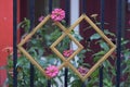 Paper flowers or dahlias growing behind a metal fence