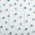 Paper frame with blue bauble, silver snowflake and star over white