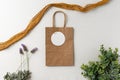 Paper gift bag and gift tag mockup on a light background with greens, lavender and mustard yellow