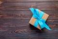 Paper gift box with blue ribbon on dark wood background. top view with copy space Royalty Free Stock Photo