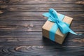 Paper gift box with blue ribbon on dark wood background. top view vintage, toned with copy space Royalty Free Stock Photo