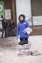 Paper girl selling newspapers standing on the street. Kyiv, Ukraine