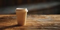 A paper glass of coffee with a lid stands on a wooden table Royalty Free Stock Photo