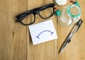 Paper with glasses and pens on wooden boards using business for emotion to bad Royalty Free Stock Photo