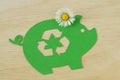 Paper green piggy bank with recycling symbol and daisy flower - Concept of saving money, ecology and recycling