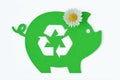 Paper green piggy bank with recycling symbol and daisy flower on white background - Concept of saving money, ecology and recycling