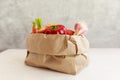 Paper grocery bag with fruits and vegetables over white background, eco shopping, zero waste, vegetarian concept Royalty Free Stock Photo