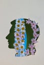 a paper head with leaves and flowers going down, a creative depiction of how thoughts flow through the head and brain Royalty Free Stock Photo
