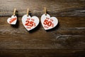 Paper hearts with discounts on the clothespins on the rope isolated on brown wooden background. Big sale 14 february