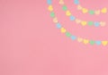 Paper hearts of pastel tones on a pink background