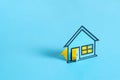 Paper house on blank blue background Royalty Free Stock Photo