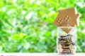 Paper house, Coins in jar on wooden table Royalty Free Stock Photo
