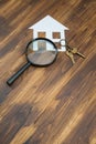 Paper house and key with Magnifying Glass, House hunting Royalty Free Stock Photo